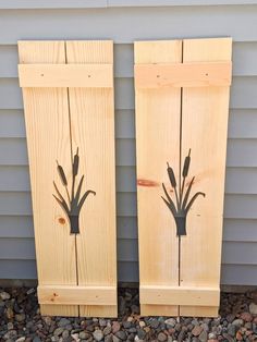 two wooden panels with plants painted on them