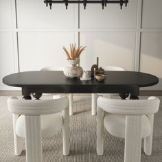 a black table with two white chairs and a vase on it in front of a wall