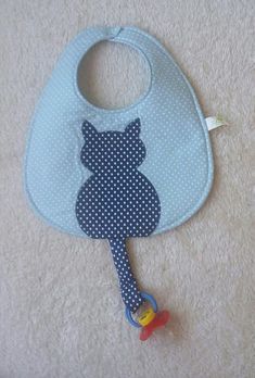 a bib with a bear on it and a pacifier hanging from the side