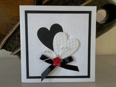 a card with two hearts on it and a ribbon attached to the front of it