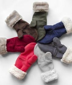 five pairs of mittens laying on top of each other in different colors and sizes