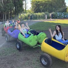 several people riding on four wheeled cars in the park