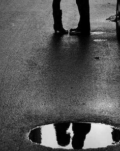 a man and woman standing next to each other in the rain