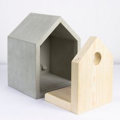 a small concrete house next to a wooden block