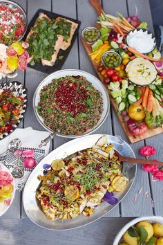 a table topped with lots of different types of food on plates and serving utensils