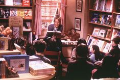 a group of children sitting in front of bookshelves