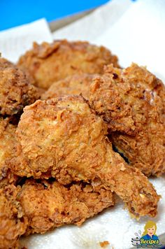 some fried food on a white plate next to a potted plant and glass table