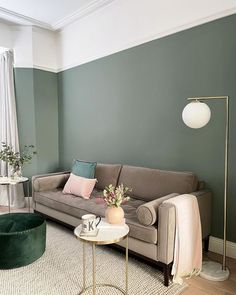 a living room filled with furniture and green walls