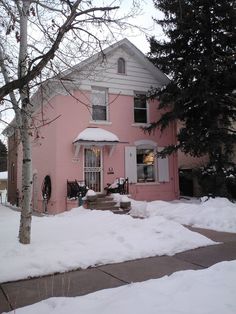 a pink house with snow on the ground