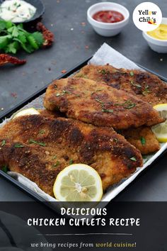 chicken cutlets on a plate with lemons and ketchup