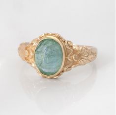 This vintage style sea-themed signet ring, featuring beautiful little shells and ocean-inspired fluorishes all around the center which displays a lovely bright green peridot or sea-blue aquamarine cabochon.  (NOTE: Please SELECT and state in the order notes the stone you prefer in the listing!) This ring can be customized with any letter or word (provided it fits) and is made in solid gold. This ring can be made for men or women and in your preferred size or color of gold. A phrase or letter may Aesthetic Vintage Rings, Vintage Engraved Cabochon Ring As Gift, Handmade Vintage Green Signet Ring, Vintage Handmade Green Signet Ring, Vintage Adjustable Emerald Ring, Vintage Oval Engraved Emerald Ring, Vintage Oval Emerald Ring Engraved, Vintage Engraved Ring With Birthstone, Vintage Blue Handmade Signet Ring