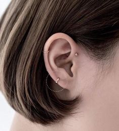 an ear with two piercings attached to it, and the word think written below