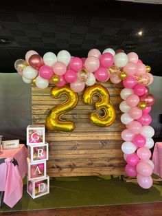 the balloon arch is decorated with pink, white and gold balloons that spell out the number twenty two