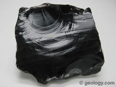 a piece of black rock sitting on top of a white table