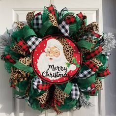 a christmas wreath with a santa clause on it and leopard print ribbon around the front door