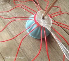 a metal object with red wires attached to it on a wooden floor next to a blue ball