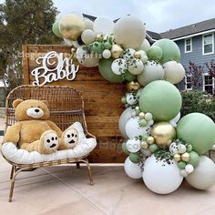 a teddy bear sitting on top of a chair next to a bunch of balloons in front of a sign