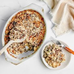 a casserole dish with meat and cheese on it next to a plate full of food