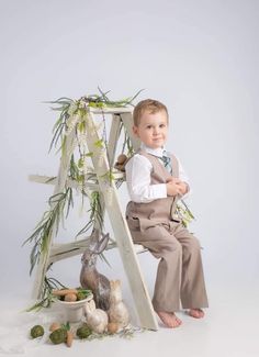 a young boy is sitting on a ladder