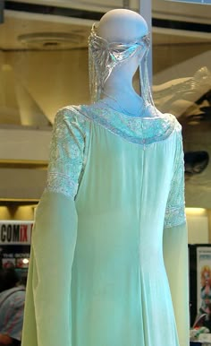 the back of a woman's green dress on display in a storefront window