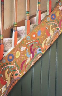 there is a colorful stair case on the side of a building with decorative designs and wooden poles