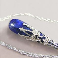 Elegant pendant necklace featuring genuine blue Lapis Lazuli gemstone drop accented with a silver, Victorian style, filigree bead cap. It is suspended from an elegant Sterling Silver chain closed with a lobster claw clasp. More details: - Natural Lapis Lazuli drop Gemstone, approx. 10mm x 30mm  - 925, Sterling Silver chain, wire and lobster claw clasp - Top quality Sterling silver plated intricate brass filigree bead-cap (Nickel and Lead-free) - Czech Crystals, 3mm - The Pendant is approx. 52mm ( 2") long - Choose the length of the necklace from the drop down menu options.  --- Please, keep in mind that the jewelry in the photographs looks larger than it does in person. I post close up pictures to show the details in the jewelry. --- All of the designs in my shop are handmade by me in my V Silver Crystal Necklace, Blue Gemstone Necklace, Crystal Necklace Silver, Blue Stone Pendant, Chain Necklace Silver, Lapis Jewelry, September Birthstone Jewelry, Lapis Lazuli Jewelry, Crystal Amethyst