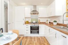 a kitchen with wooden floors and white cabinets