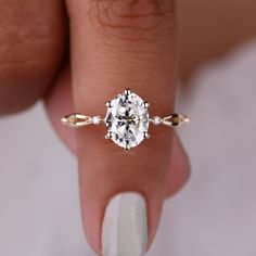 a woman's hand holding a diamond ring