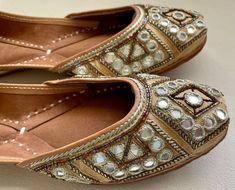 Add a vintage spark to your casual attire with our 'GLITTER GOLD' juttis. A little bit of beads and a little bit of mirrors. WEDDING AND FESTIVE pair of shoes to solve all your wardrobe woes and create a mark wherever you go :) SPECIFICATIONS: *Upper/Panna -Gold fabric base embellished with mirror, gold beads, pipes and zari work. *Back/Adda - Gold fabric base embellished with mirror, gold beads, pipes and zari work. *Lining - Leather *Padding - Double Cushioning for extra comfort *Sole/Talla - Bollywood Style Festive Flats With Mirror Work, Bollywood Style Flats With Mirror Work For Festive Occasions, Bollywood Style Flats With Mirror Work For Party, Festive Diwali Flats With Mirror Work, Bollywood Style Party Flats With Mirror Work, Transitional Festive Flats With Mirror Work, Festive Mirror Work Closed Toe Flats, Festive Mirror Work Flats, Party Flats With Mirror Work For Festivals