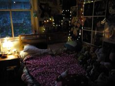 a bedroom with teddy bears all over the bed and lights shining on the window sill