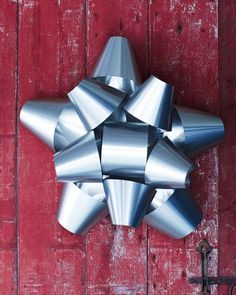 a large metal bow hanging on the side of a red door next to a key