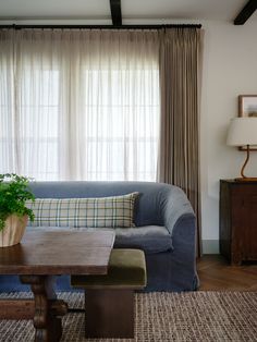 a living room with a blue couch and wooden table