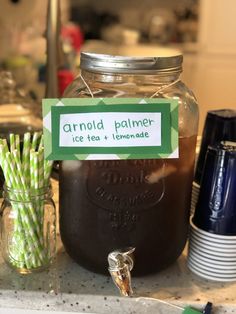 a jar filled with ice tea and lemonade sitting on top of a kitchen counter