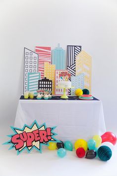 the table is decorated with colorful balloons and paper cutouts for an instagram party