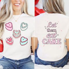 Add a sweet touch to your Valentine's Day in our cute and cozy, Let Them Eat Cake T-shirt. The front of our valentine tshirt features 5 heart cakes with the words Let Them Eat Cake printed on the back. This irresistibly sweet graphic tee makes the cutest gift for all the Galentines in your life.  Comfort Colors garment-dyed t-shirt is a soft-washed, garment-dyed fabric that brings extra coziness to your wardrobe while the relaxed fit makes it an excellent daily choice. The double-needle stitching throughout the tee makes it highly durable while the lack of side-seams helps the shirt retain its tubular shape.  .: The Comfort Colors 1717 tee is made with medium fabric consisting of high quality, 100% ring-spun US cotton for long-lasting comfort. .: The relaxed fit keeps the wearer comfy in b Sweet Crew Neck T-shirt For Gift, Sweet Letter Print T-shirt For Gift, Cute White T-shirt For Valentine's Day, Cute White Valentine's Day T-shirt, Valentine's Day Graphic Tee T-shirt, Pink Valentine's Day Graphic Tee, White T-shirt With Heart Graphic For Valentine's Day, Valentine's Day Heart-shaped Graphic Tee, Casual Valentine's Day T-shirt With Heart Graphic