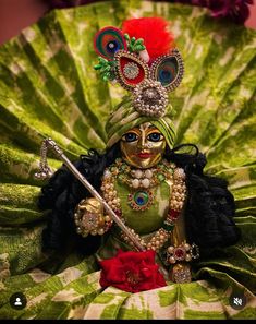 a close up of a figurine on a green leaf with a red rose