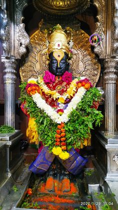 the statue is decorated with flowers and leaves