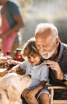 an older man and young child petting a dog