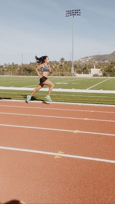 a woman running on a track in the sun