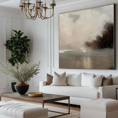 a living room filled with furniture and a large painting on the wall above it's coffee table