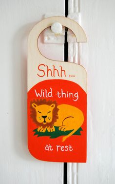 a wooden door hanger with an image of a lion and the words shh wild thing at rest