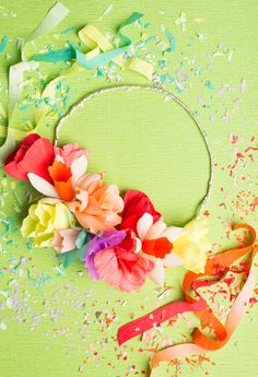 colorful paper flowers and confetti on green background with space for text or image