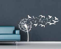 a living room with a couch and a wall sticker on the wall that has a dandelion blowing in the wind