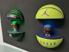 three basketballs are hanging on the wall next to pop - up figurines