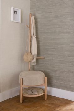 a white chair sitting next to a wall with a scarf hanging on it's back