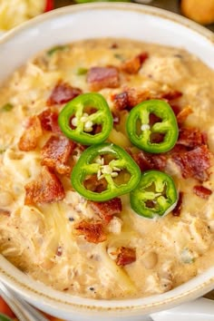 chicken jalapeno popper chili in a white bowl with green peppers on top