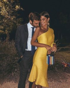 a man standing next to a woman in a yellow dress