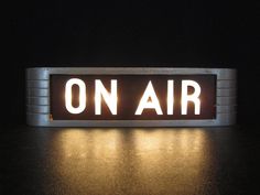 an on air sign lit up at night with the word on air spelled in white letters