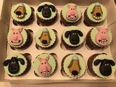 twelve cupcakes with farm animals on them in a box