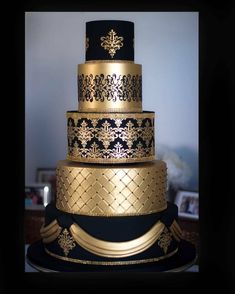 a three tiered black and gold wedding cake